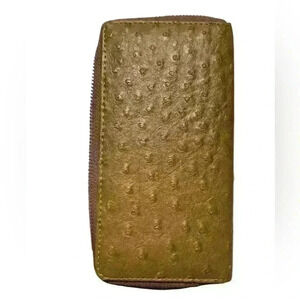 A woman’s brown wallet with ostrich leather print type pattern.